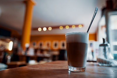 Close-up of coffee latte glass on table