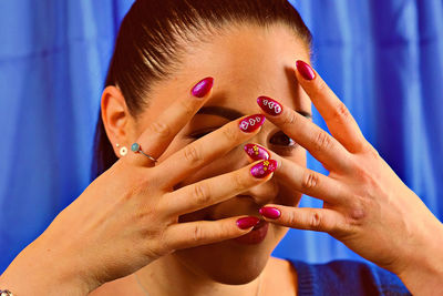 Portrait of woman showing painted fingernails