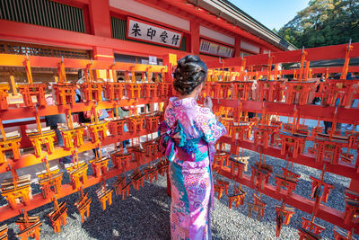 Rear view of woman standing against orange wall