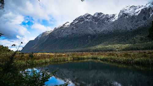 Scenic view of lake by mountains against sky