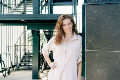 Portrait of young woman standing in city