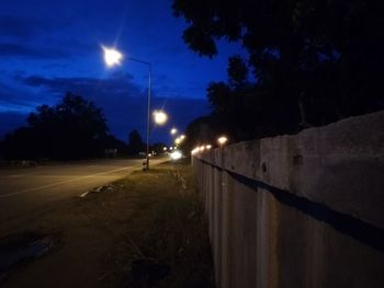 Illuminated street lights on road at night