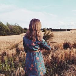 Woman standing on field against sky