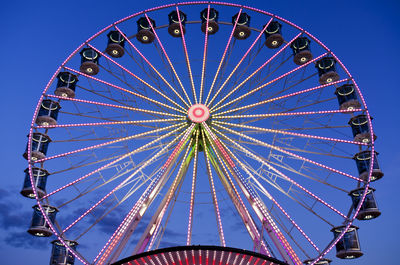 Low angle view of ferris wheel against blue sky