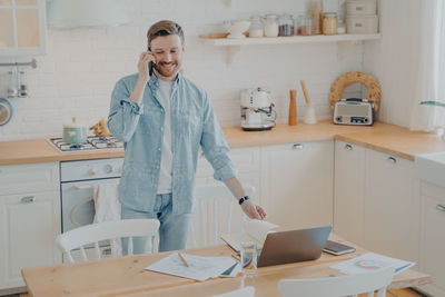 Man talking on phone while standing at home