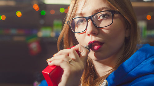 Close-up portrait of young woman smoking electronic cigarette