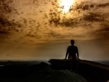 Silhouette of woman looking at sunset