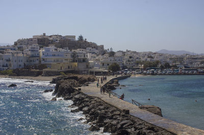 Scenic view of sea by buildings against clear sky