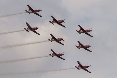 Low angle view of fighter planes flying against sky