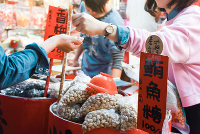 Woman buying pistachio from market vendor
