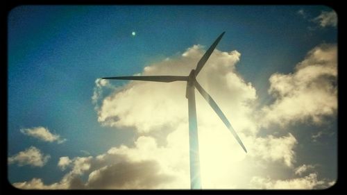 Low angle view of windmill against blue sky