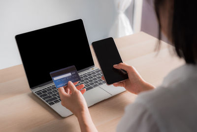 Midsection of woman using laptop