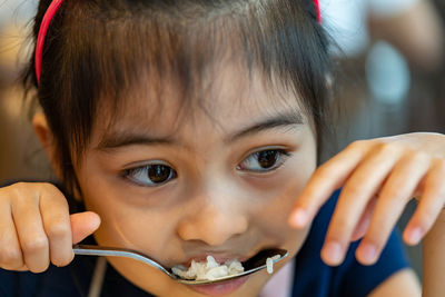 Close-up of cute girl eating food at restaurant