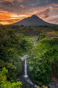 Scenic view of waterfall during sunset