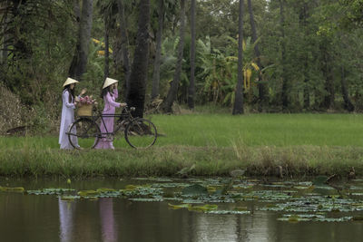 People riding bicycles on lake in forest