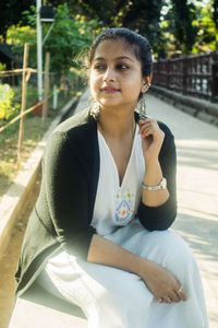 Portrait of smiling young woman sitting outdoors