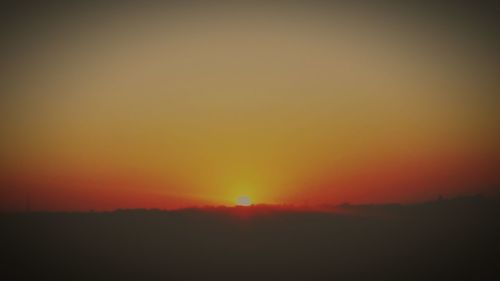 Scenic view of silhouette landscape against orange sky