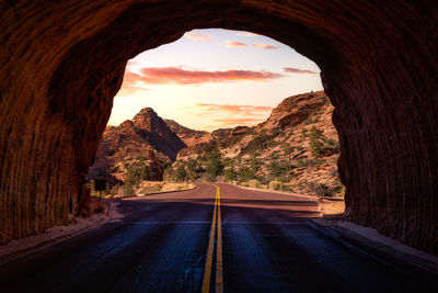 Road leading towards mountains against sky