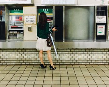 Full length of woman standing by railing