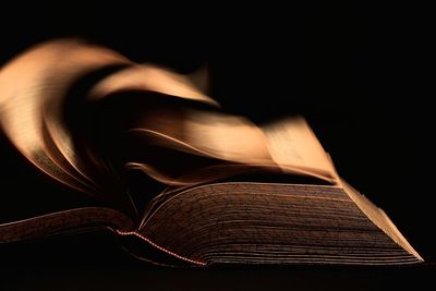 Close-up of open book against black background