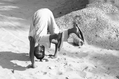 Woman sitting on sand at beach