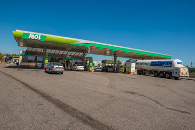 Vehicles on road against blue sky