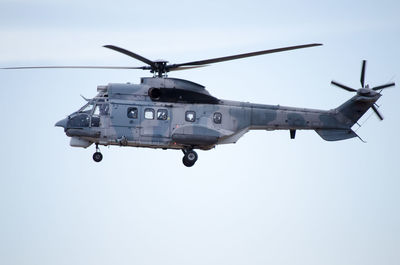 Low angle view of helicopter flying against clear sky