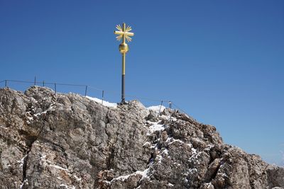 Low angle view of rocky mountains against clear blue sky