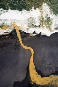 Aerial view of braided orange river flowing into ocean in southe