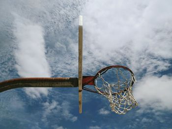 Low angle view of basketball hoop against cloudy sky