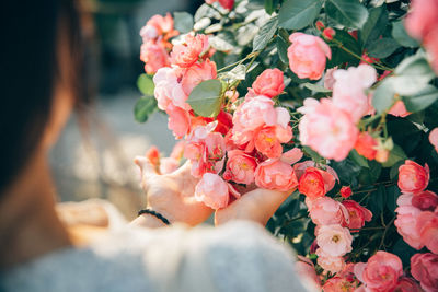 Cropped hands of woman touching bouquet