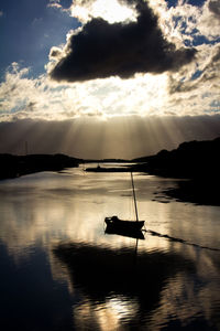 Silhouette sailboat in sea against sky during sunset