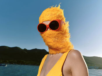 Rear view of woman wearing sunglasses against sea