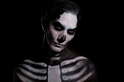 Close-up portrait of young man with halloween make-up with black background