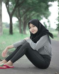 Portrait of a smiling young woman sitting outdoors