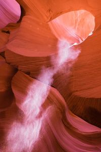 Low angle view of sunlight falling in slot canyon