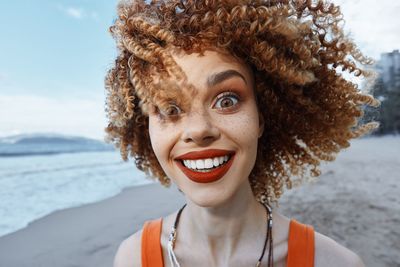 Portrait of young woman standing at beach