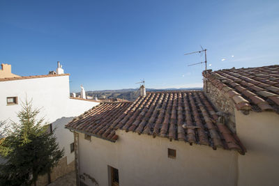 Houses in town against clear blue sky