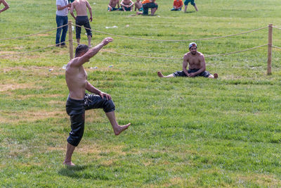 Full length of shirtless man on field