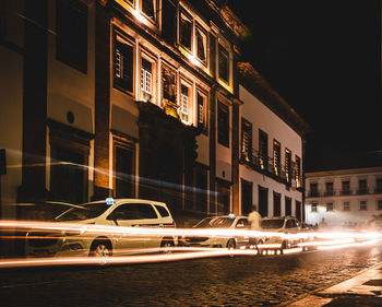 Cars on illuminated building at night