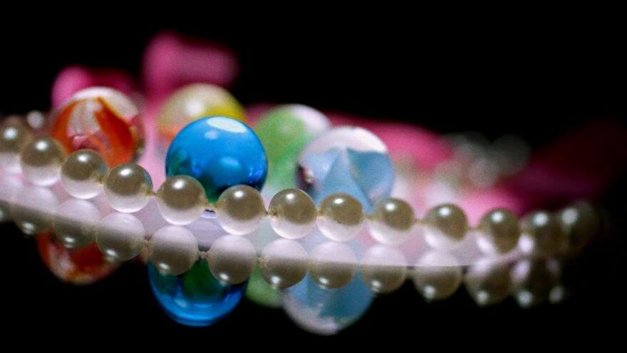 close-up, studio shot, multi colored, indoors, selective focus, black background, still life, large group of objects, focus on foreground, decoration, celebration, colorful, variation, no people, defocused, in a row, copy space, abundance, jewelry, shape