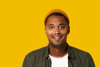Portrait of young man against yellow background