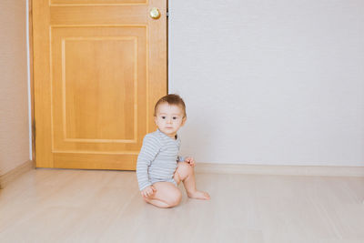 Portrait of cute girl sitting on wooden floor