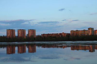 Reflection of buildings in lake against sky