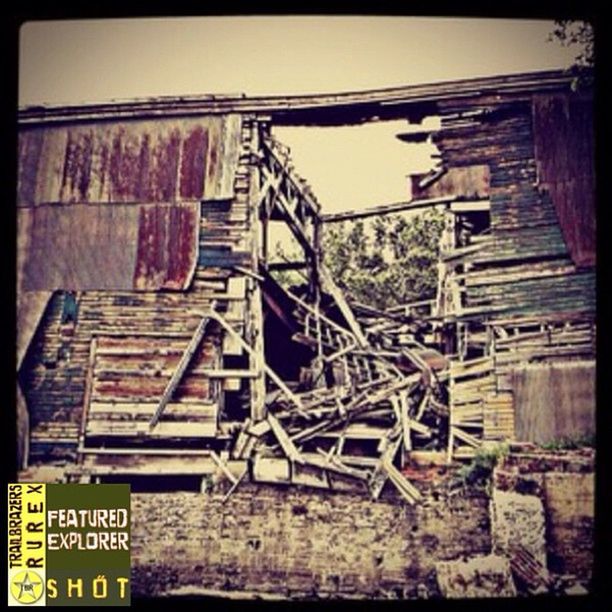 built structure, architecture, abandoned, building exterior, obsolete, deterioration, run-down, damaged, old, weathered, low angle view, text, bad condition, destruction, wood - material, house, ruined, graffiti, brick wall, day