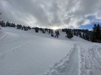 Scenic view of snow covered land against sky