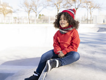 Portrait of smiling girl sitting on snow