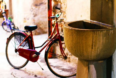 Close-up of bicycle on sidewalk by wall