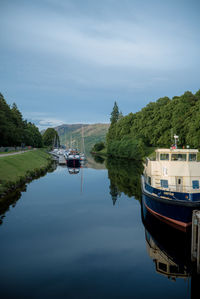 Boat sailing on river against sky