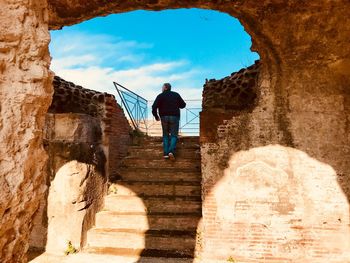 Rear view of man standing by staircase